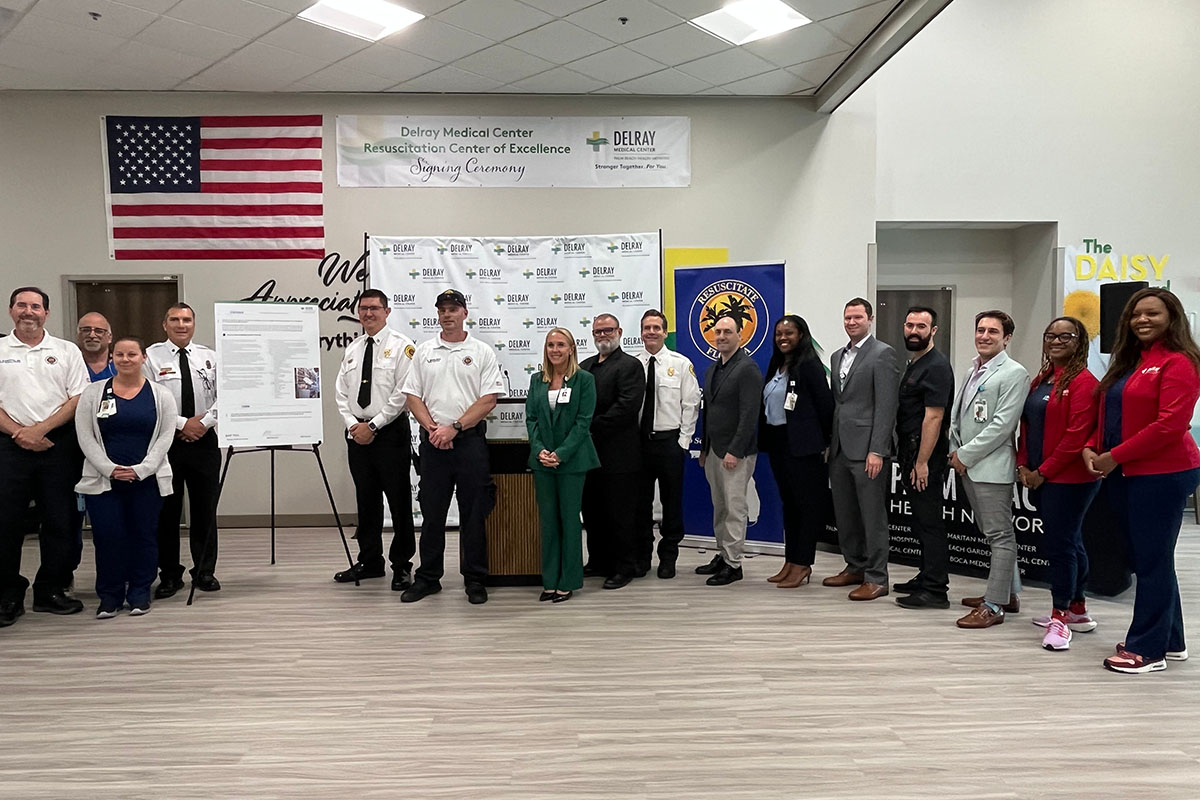 A group photograph of people in a conference room with the Resuscitate Florida banner in the background